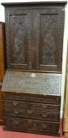 Lot 1177 - An antique low relief carved oak bureau...