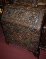 Lot 1410 - An antique low relief carved oak slopefront...