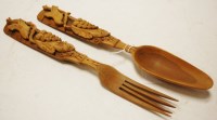 Lot 698 - A pair of wooden salad servers each carved...