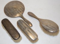 Lot 311 - A George V silver backed four piece dressing...