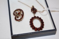 Lot 424 - A white metal garnet set pendant on fine link...