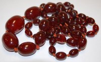 Lot 516 - A beaded cherry amber long necklace, with...