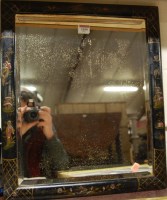 Lot 1050 - A Japanned framed and bevelled wall mirror...