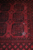 Lot 1145 - A Persian machine woven red ground Bokhara rug...