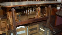 Lot 1292 - An Ercol dark elm dining table; together with...