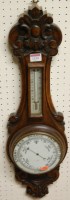 Lot 1134 - A 1930s carved oak two dial aneroid wheel...