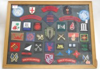 Lot 63 - A framed display of various military cloth...