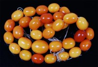 Lot 1211 - A beaded butterscotch amber single string...