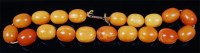 Lot 1213 - A beaded butterscotch amber single string...