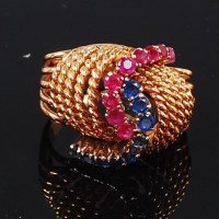 Lot 1247 - An 18ct gold, ruby and sapphire set dress ring,...