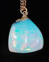 Lot 1249 - A large polished opal pendant, the natural...