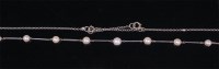 Lot 1257 - A 9ct white gold neck chain, set with nine...