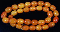 Lot 1214 - A beaded butterscotch amber single string...