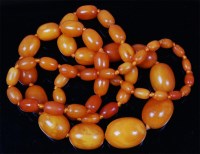 Lot 1216 - A beaded butterscotch amber single string...