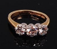Lot 1230 - An 18ct gold and diamond three stone ring, the...