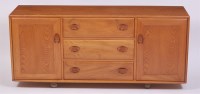 Lot 328 - An Ercol light elm long sideboard, having...