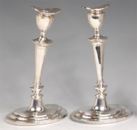 Lot 731 - A pair of Adam style silver candlesticks, each...