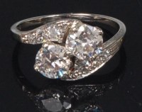 Lot 887 - A white metal and diamond crossover ring, the...