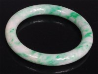 Lot 1012 - A Chinese celadon and green jade bangle, 9cm