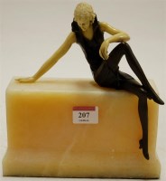 Lot 207 - An Art Deco style figure of a lady seated on a...