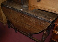 Lot 1397 - An antique oak dropleaf dining table, having...