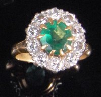 Lot 224 - An 18ct gold emerald and diamond cluster ring,...