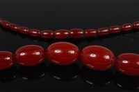 Lot 1245 - A beaded and graduated cherry amber single...