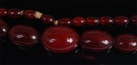 Lot 1247 - A graduated beaded cherry amber single string...