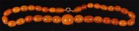 Lot 689 - A beaded cloudy amber single string necklace,...