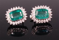 Lot 735 - A pair of 14ct white gold emerald and diamond...