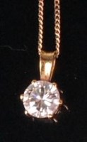 Lot 710 - A modern 18ct gold diamond pendant, the claw...