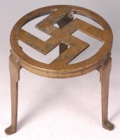 Lot 310 - A mid-20th century brass trivet with swastika...