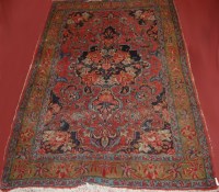 Lot 848 - A Persian sarouk woollen rug, the red ground...