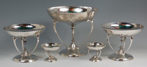 Lot 100 - A suite of five Arts & Crafts hammered silver...