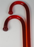 Lot 760 - Two cranberry glass walking canes, having...