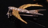 Lot 981 - An 18ct gold swallow brooch, its body set with...