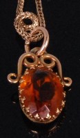 Lot 932 - A yellow metal and citrine pendant, the oval...