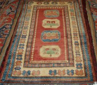 Lot 1264 - A Persian woollen Kazak rug, the red ground...