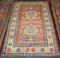 Lot 1265 - A Persian woollen Kazak rug, the ornate red...