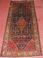 Lot 1273 - A Persian woollen rug, the black ground...