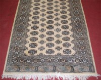 Lot 1274 - A Persian woollen beige ground Bokhara,...