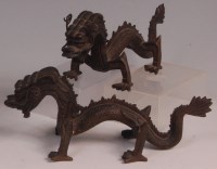 Lot 660 - A pair of Chinese bronze dragons, each in...