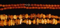 Lot 527 - A single string necklace of 63 amber beads,...