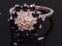 Lot 553 - An 18ct white gold sapphire and diamond flower...