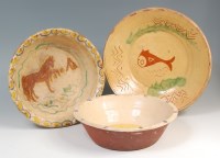 Lot 491 - Three slipware bowls, each naively decorated,...