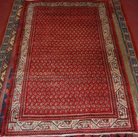 Lot 925 - A Persian woollen rug, the geometric red...