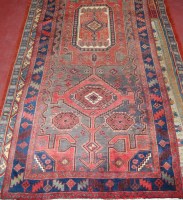 Lot 927 - A Persian woollen rug, the red ground having a...