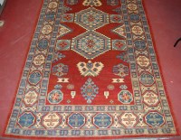 Lot 930 - A Persian woollen Kazak rug, the rust coloured...