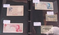 Lot 244 - A folder of various world banknotes; Canada,...