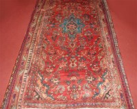 Lot 690 - A Persian woollen rug, the red ground having a...